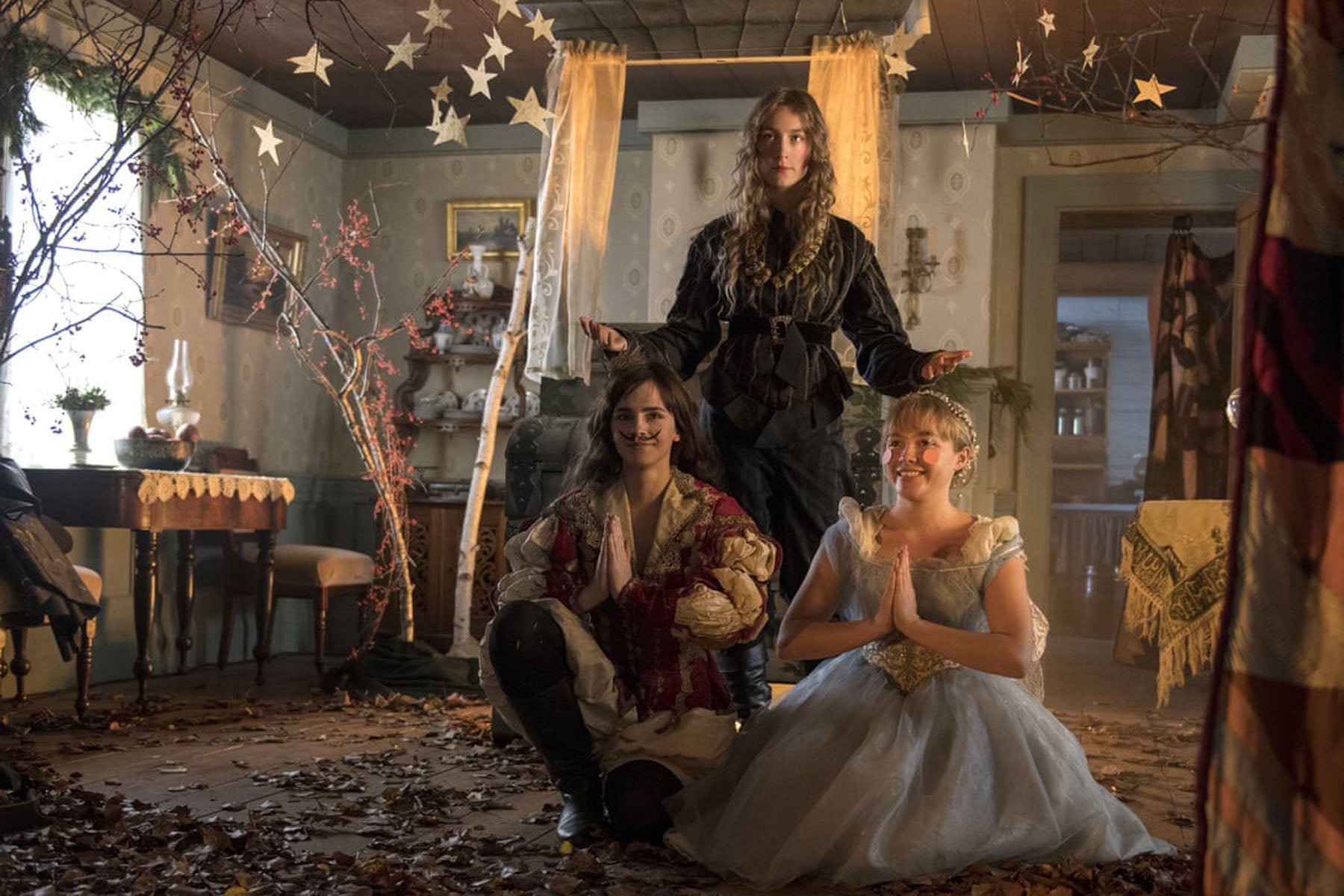 Screen still from Greta Gerwig's 2019 Little Women featuring three of the March sisters dressed up for a Christmas play in their living room